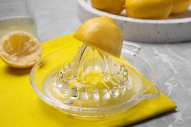 Photo of Glass citrus juicer and squeezed lemon on table