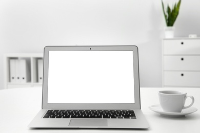 Comfortable workplace with modern laptop on table in office. Mockup for design