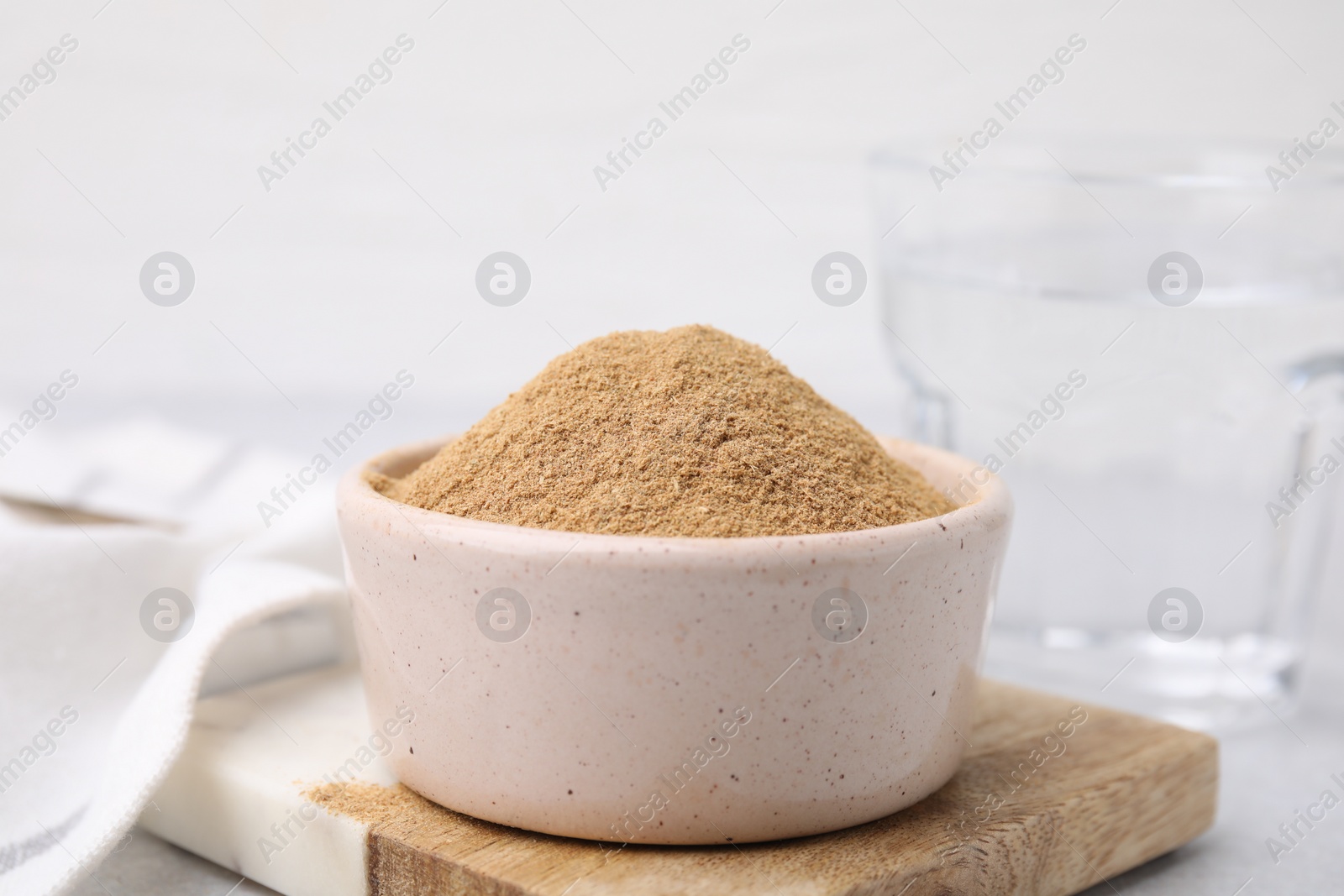 Photo of Dietary fiber. Psyllium husk powder in bowl on table