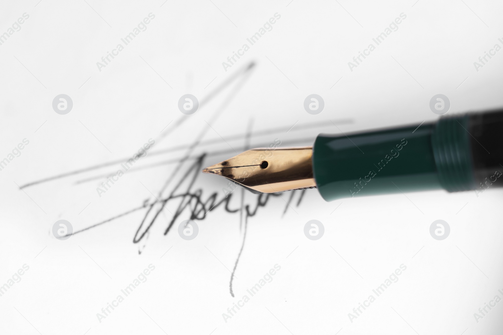 Photo of Fountain pen and signature on sheet of paper, closeup