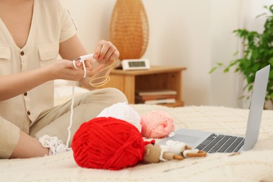 Photo of Closeup view of woman learning to knit with online course at home, space for text. Handicraft hobby