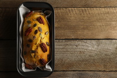 Photo of Delicious pumpkin bread with pecan nuts on wooden table, top view. Space for text