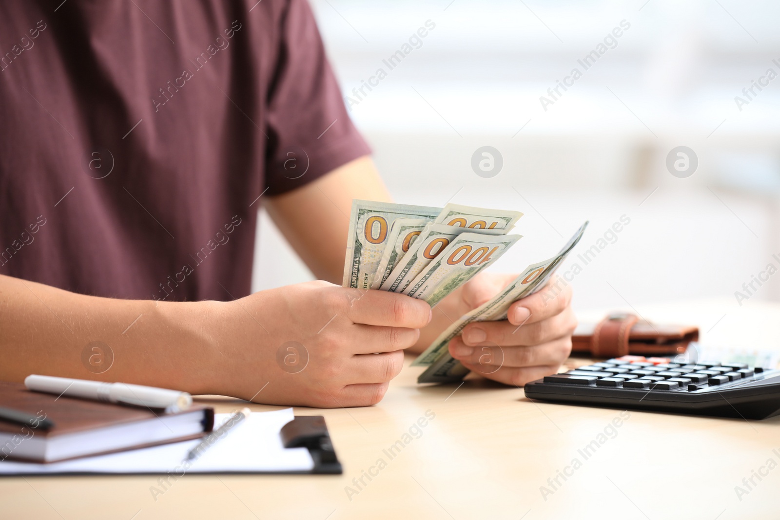 Photo of Man counting American money at table, closeup
