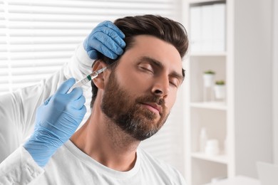 Trichologist giving injection to patient in clinic, closeup