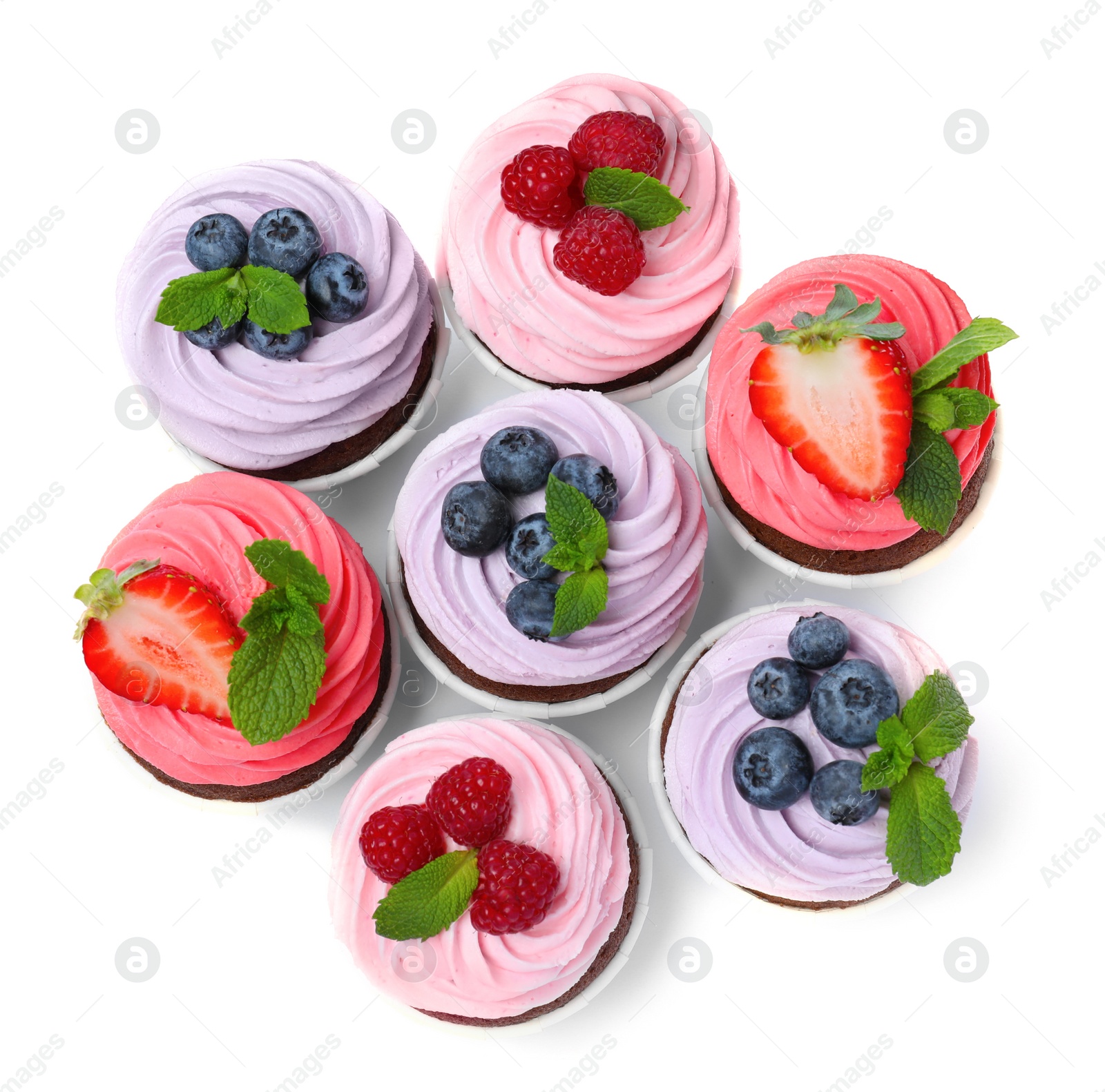 Photo of Sweet cupcakes with fresh berries on white background, top view