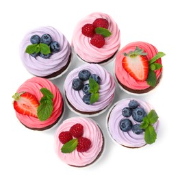 Sweet cupcakes with fresh berries on white background, top view