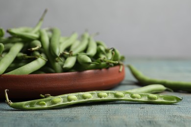 Photo of Fresh green beans on blue wooden table, closeup