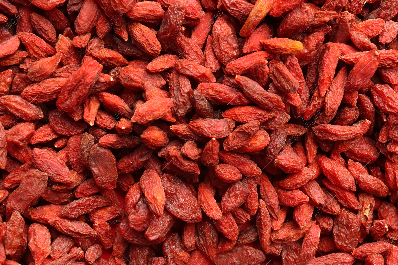 Photo of Many dried goji berries as background, closeup. Healthy superfood