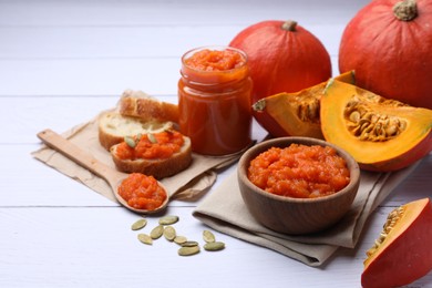 Delicious pumpkin jam and fresh pumpkins on white wooden table