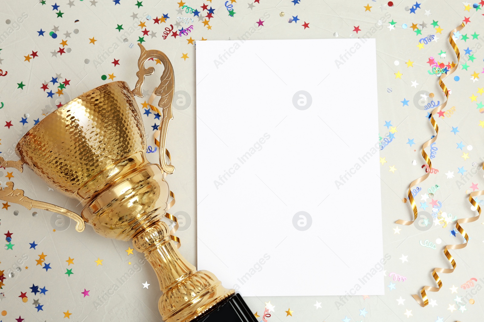 Photo of Trophy and blank paper on light background, top view with space for text. Victory concept