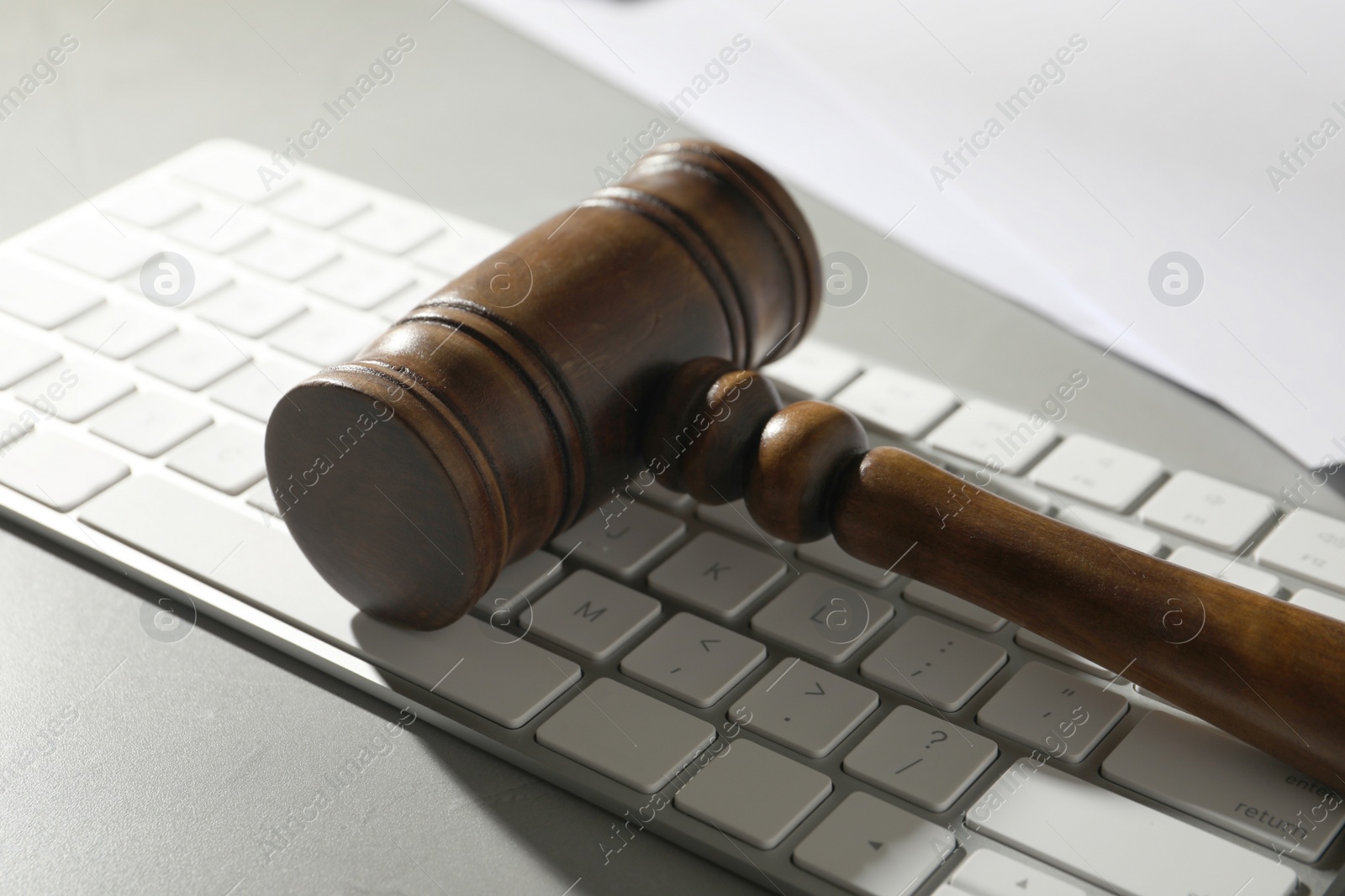 Photo of Gavel and computer keyboard on grey table. Cyber crime