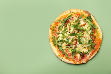 Photo of Delicious vegetarian pizza on green table, top view. Space for text