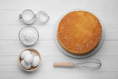 Photo of Plate with delicious sponge cake and ingredients on white wooden table, flat lay