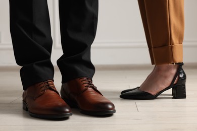 Businessman and businesswoman in elegant shoes indoors, closeup