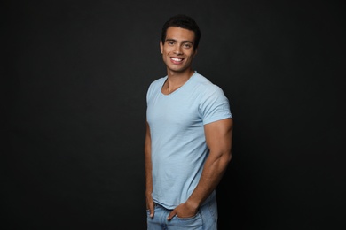 Photo of Handsome young African-American man on black background