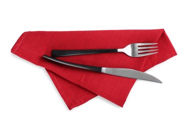 Photo of Red napkin with fork and knife on white background, top view
