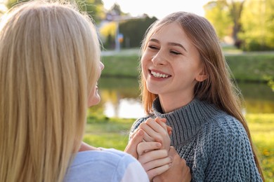 Photo of Happy daughter with her mother spending time together in park on sunny day