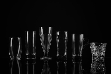 Photo of Set of empty glasses on black background