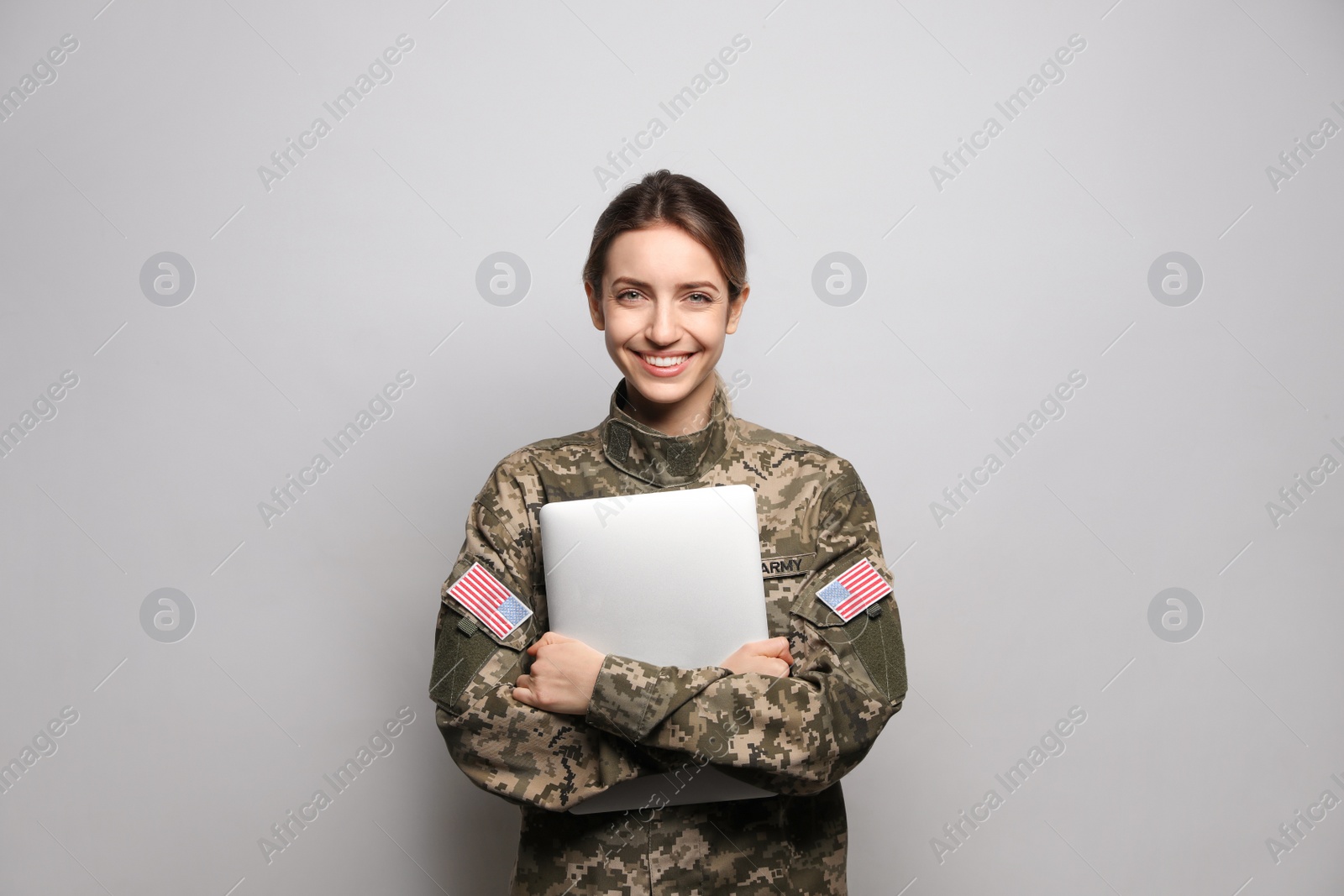 Photo of Female cadet with laptop on light grey background. Military education