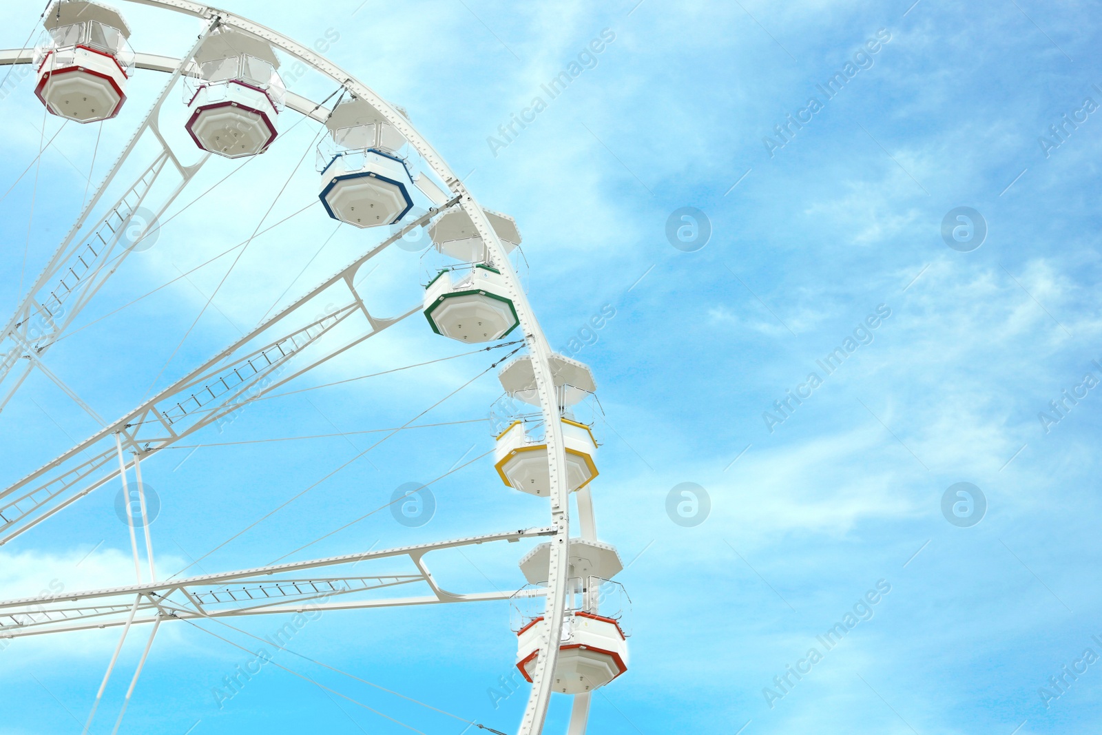 Photo of Large white observation wheel against sky, space for text