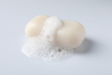 Photo of Soap with fluffy foam on white background