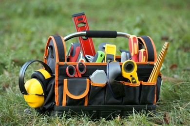 Photo of Bag with different tools for repair on grass outdoors