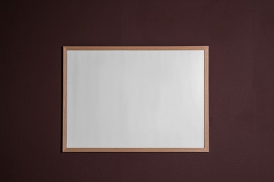 Photo of Empty frame on brown wall. Mockup for design