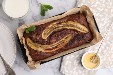 Photo of Delicious banana bread served on white marble table, flat lay