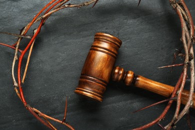 Photo of Crown of thorns and judge gavel on black table, flat lay