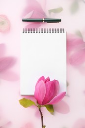 Photo of Guest list. Notebook, pen and magnolia on spring floral background, flat lay