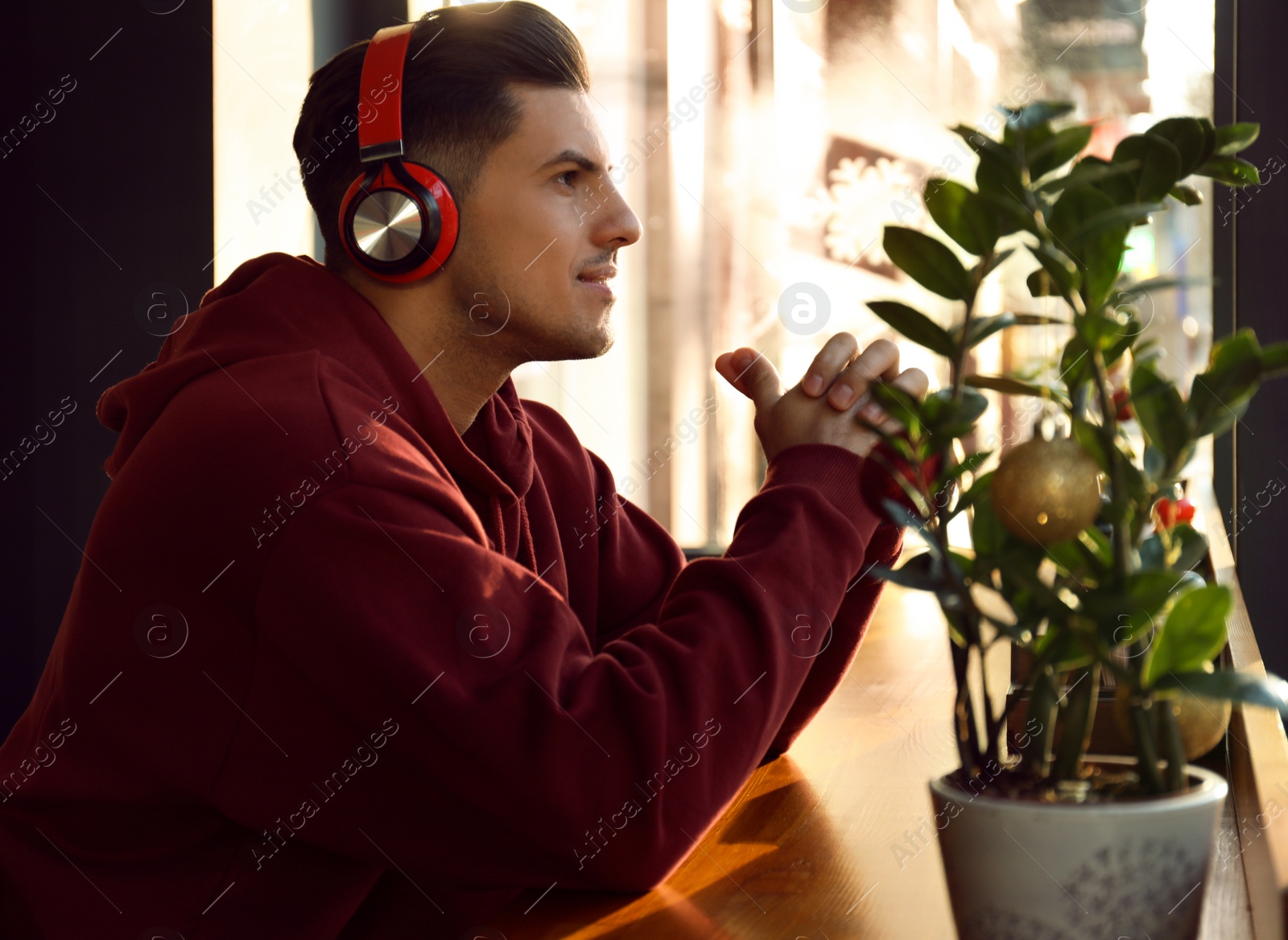 Photo of Man listening to audiobook at table in cafe