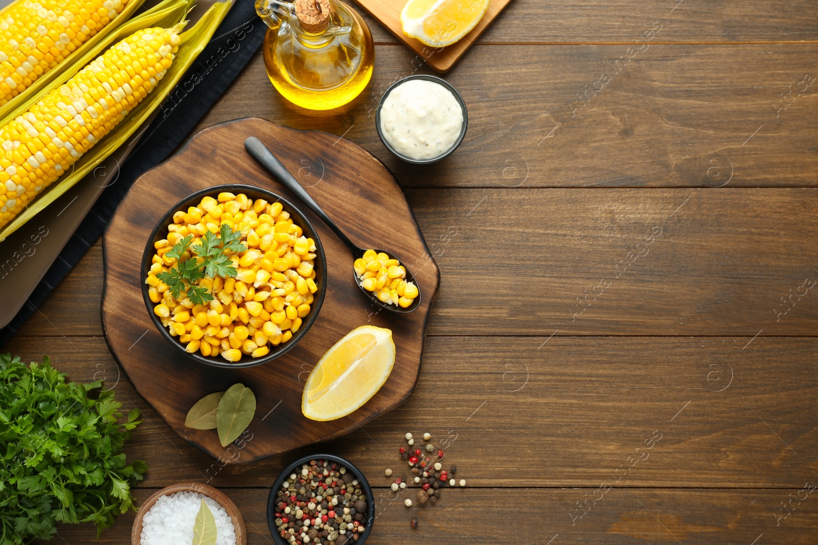 Photo of Flat lay composition with tasty boiled corn on wooden table. Space for text