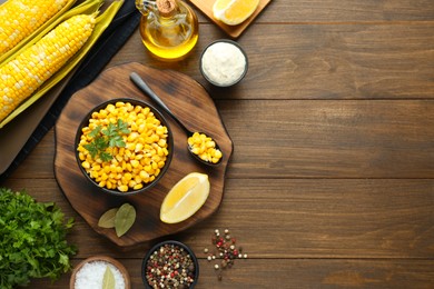 Flat lay composition with tasty boiled corn on wooden table. Space for text