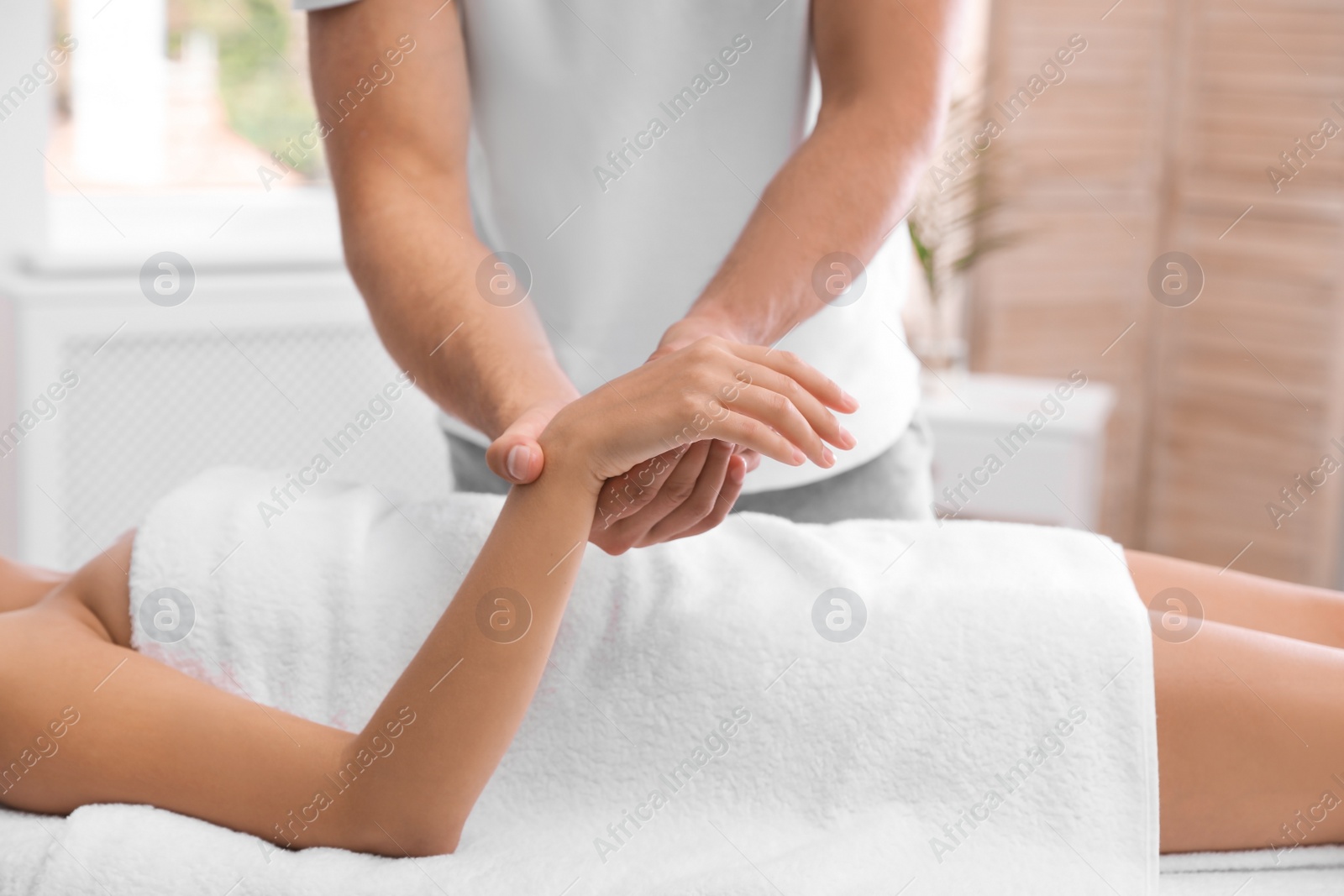 Photo of Young woman receiving massage in salon, closeup