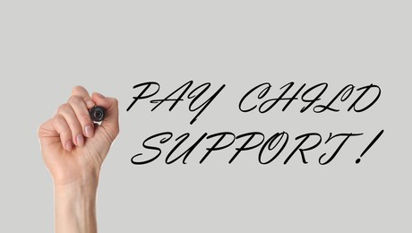 Image of Woman with marker and phrase PAY CHILD SUPPORT! on light background, closeup. Banner design