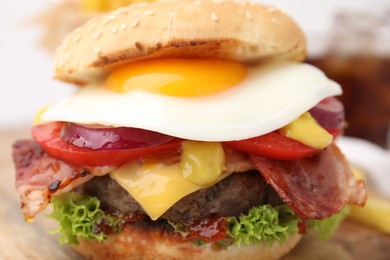 Photo of Delicious burger with fried egg on table, closeup