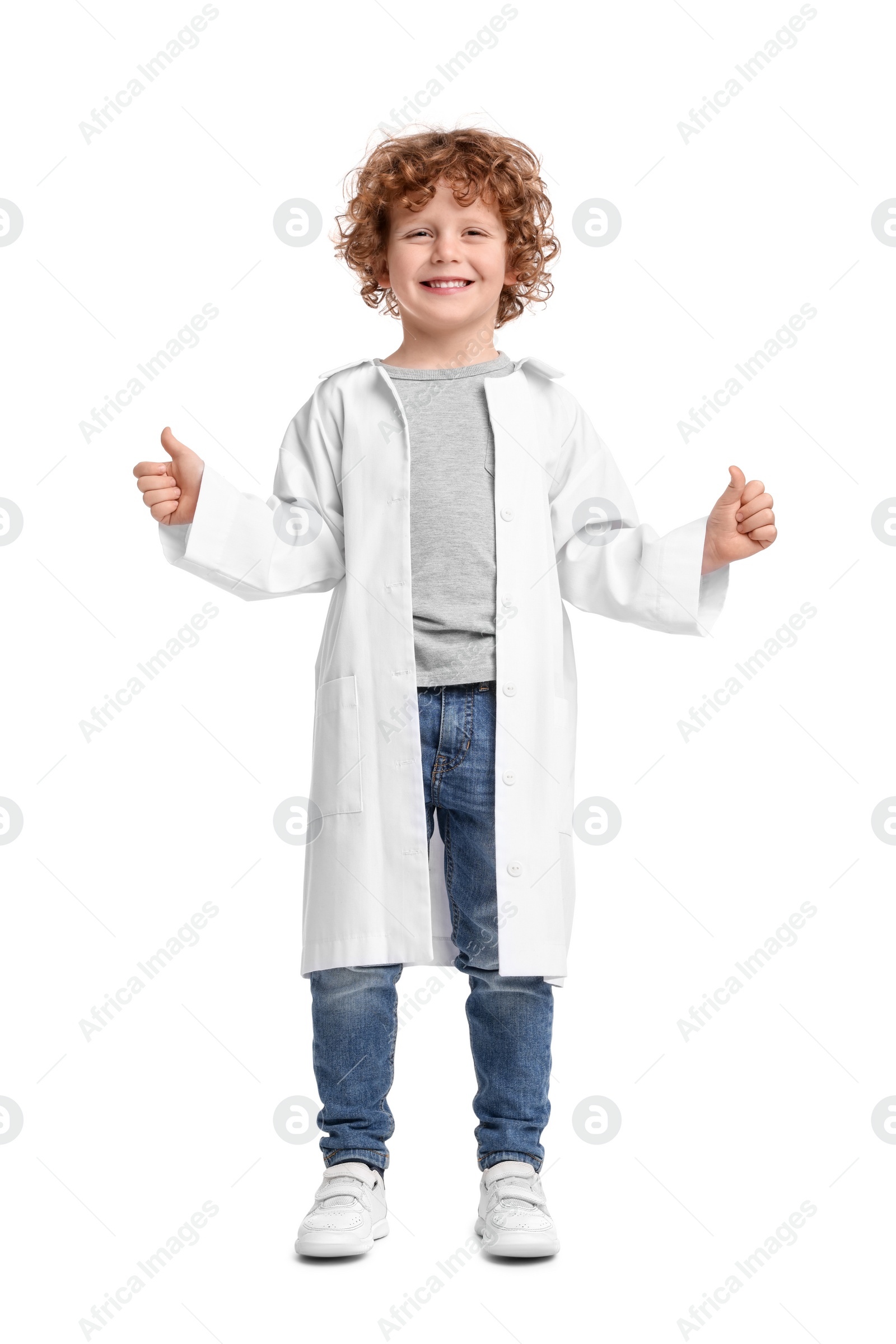 Photo of Little boy in medical uniform showing thumbs up on white background