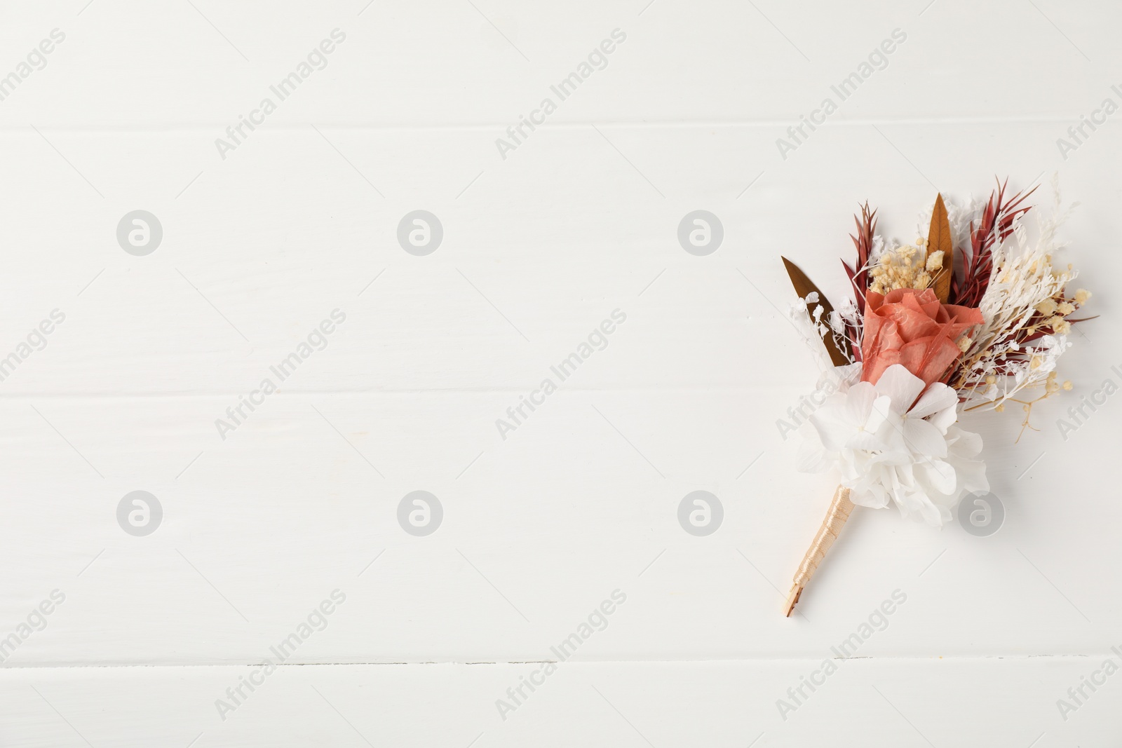 Photo of Beautiful boutonniere on white background, top view. Space for text