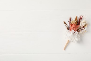 Photo of Beautiful boutonniere on white background, top view. Space for text