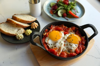 Tasty Shakshouka served on white marble table