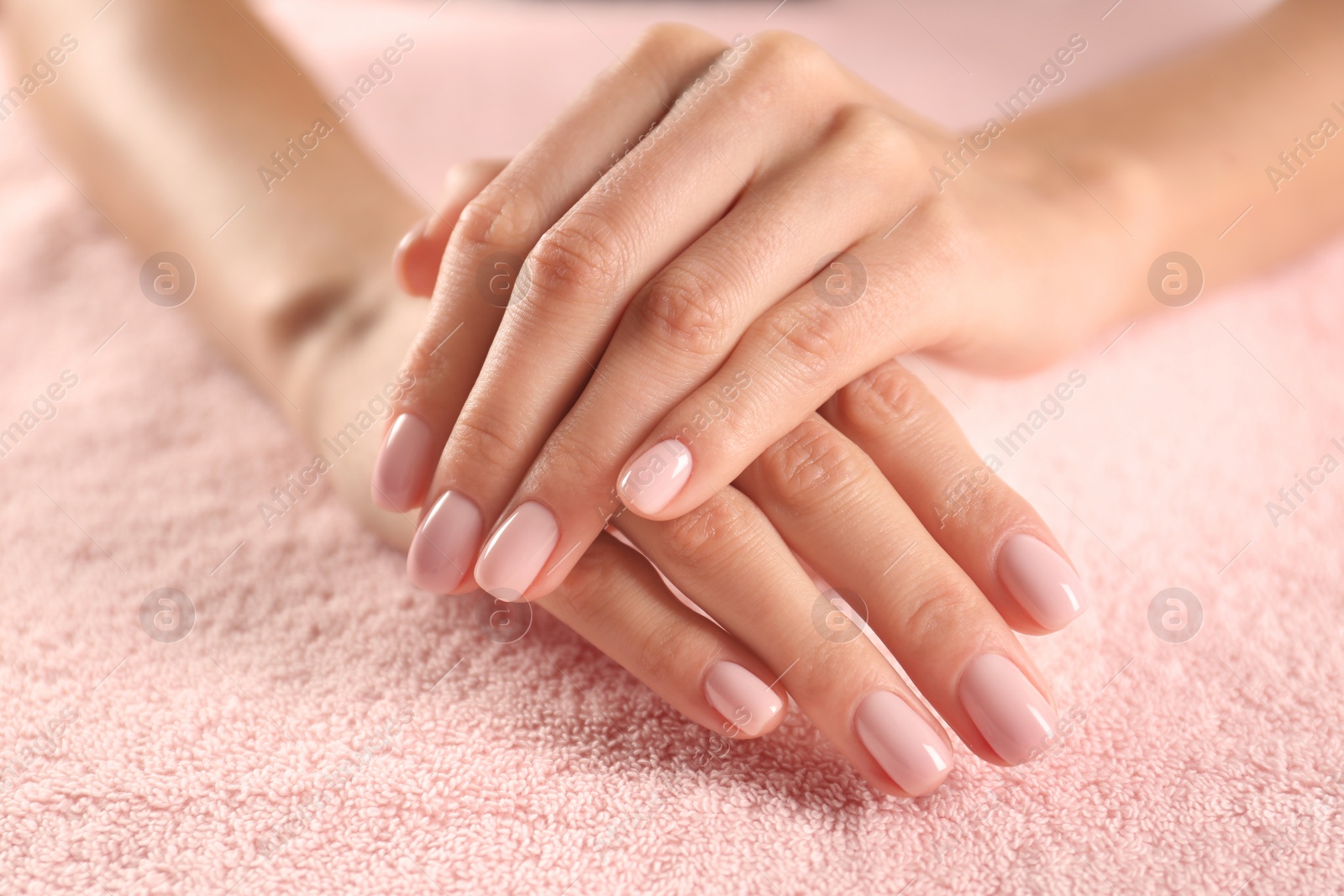Photo of Closeup view of beautiful female hands on towel. Spa treatment