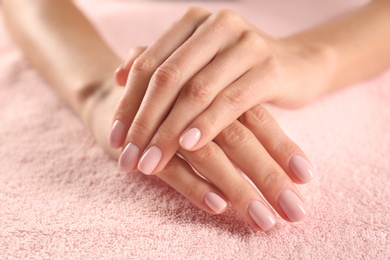 Photo of Closeup view of beautiful female hands on towel. Spa treatment