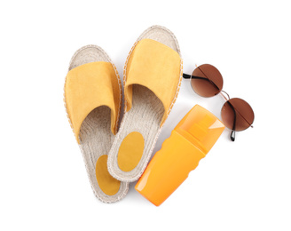 Shoes, sunscreen and sunglasses on white background, top view. Beach objects