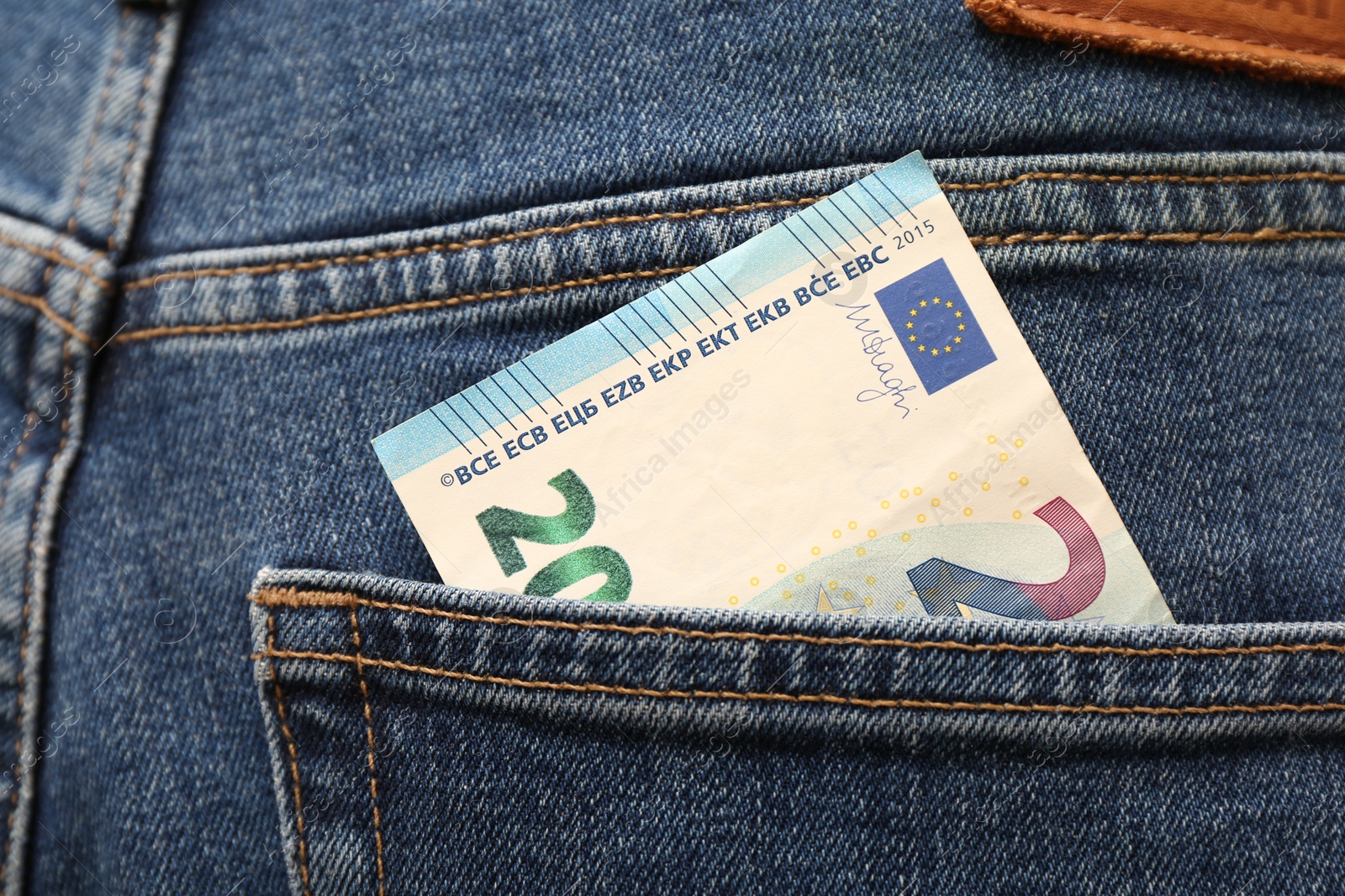 Photo of Euro banknote in pocket of jeans, closeup. Spending money