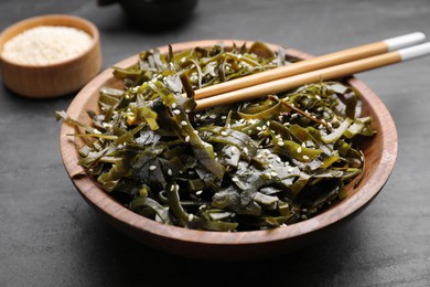 Photo of Fresh laminaria (kelp) seaweed served on black table, closeup