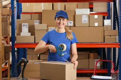 Photo of Post office worker packing parcel near rack indoors
