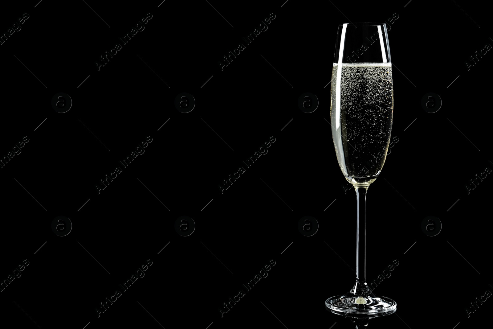 Photo of Glass of champagne on black background, space for text