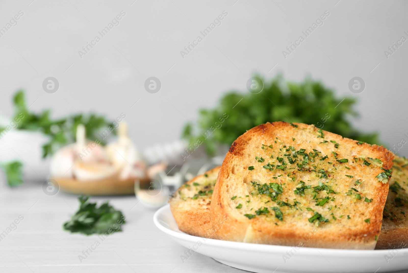 Photo of Slices of toasted bread with garlic and herbs on blue wooden table. Space for text