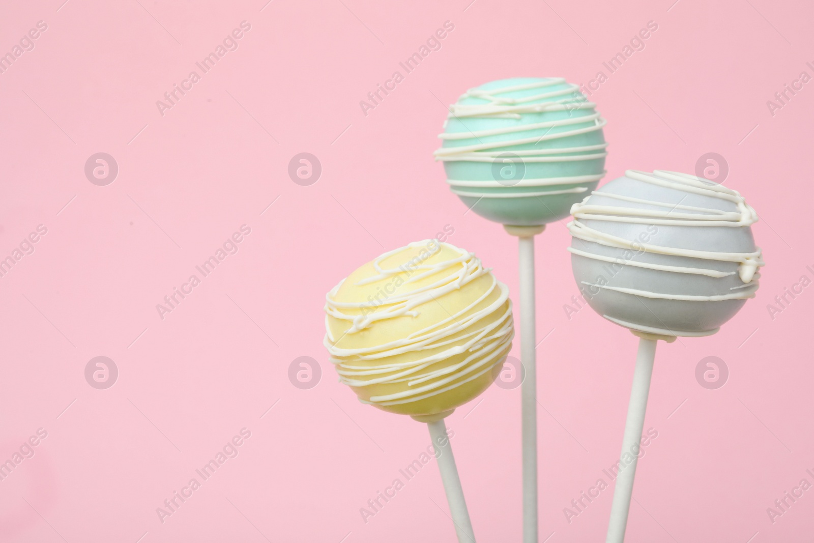 Photo of Sweet colorful cake pops on pink background