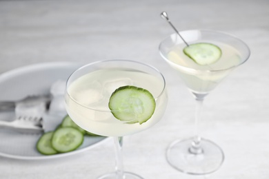 Glasses of tasty cucumber martini on grey table